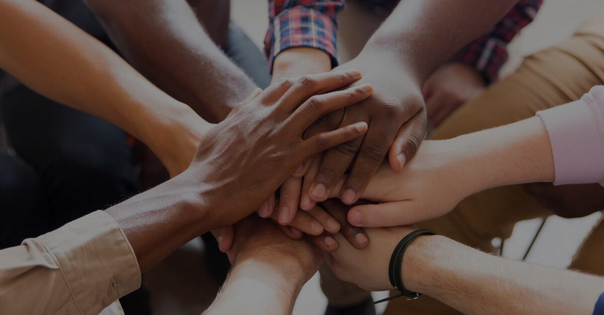 an image of multiple hands held together in the centre